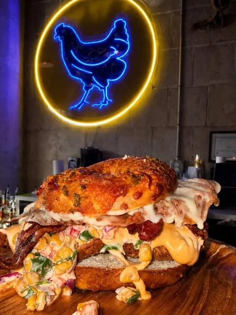 Inside Pop-Up Hot Chicken under the neon hen